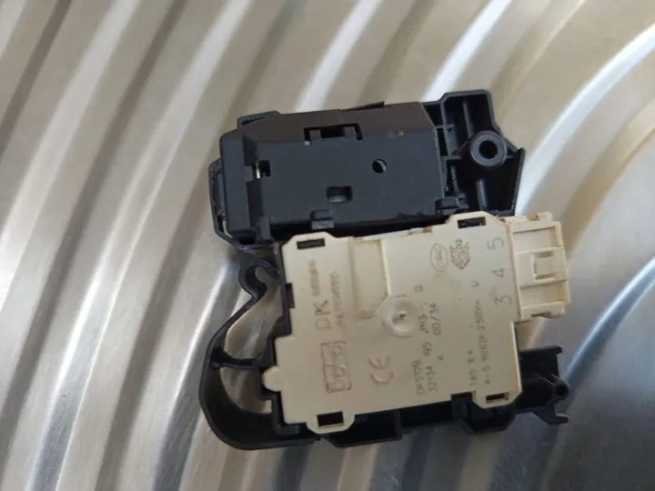 Washing machine door lock part on top of a drum