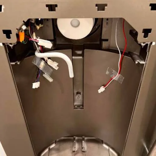 Inside the base of a water dispenser showing the wiring and hoses